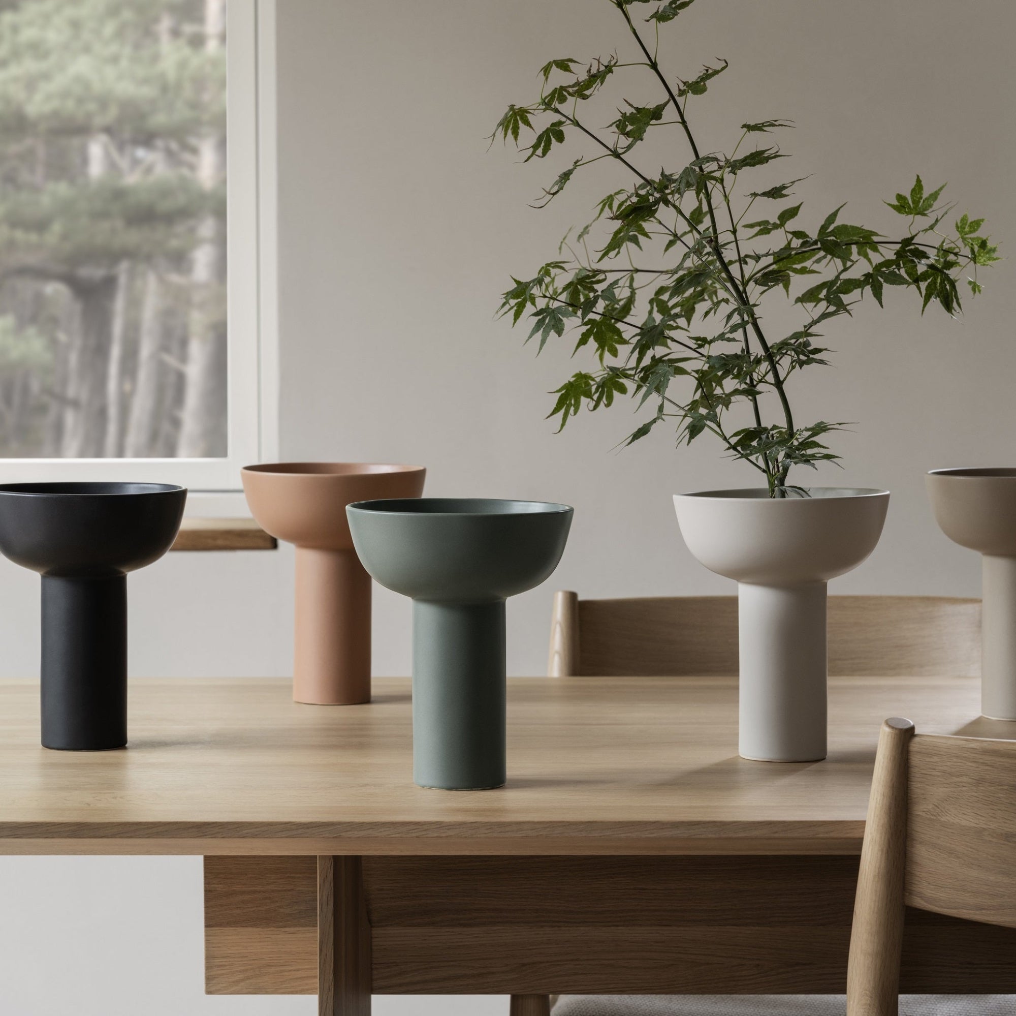elegant MIYABI vases displayed in all available colors on a wood dining table
