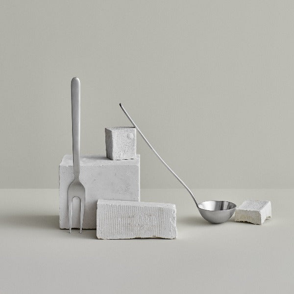modern stainless kitchen utensils by blomus STELLA arranged on a minimalist grey background