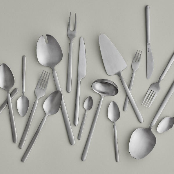 sleek minimalist brushed stainless cutlery by blomus STELLA arranged on a light grey background