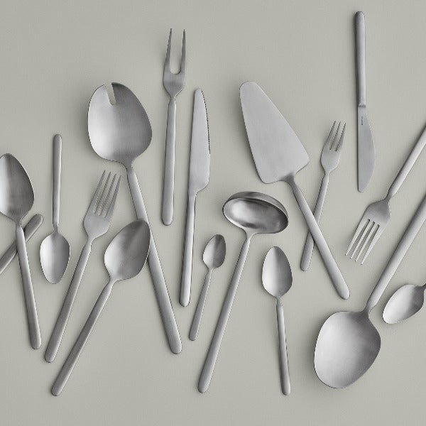 sleek modern blomus STELLA cutlery with brushed stainless steel finish on a simple grey background