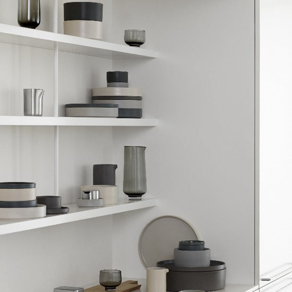 minimalist white shelves showcasing the soft matte exterior and stackable convenience of blomus PILAR stoneware in multiple colors