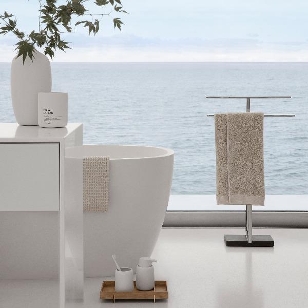 Minimalist white bathroom with oceanview window featuring blomus SONO line of silicone coated ceramic accessories